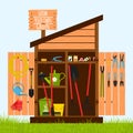 Wooden shed on the lawn with open doors. Gardening tools are stacked inside on shelves and hung on the door. A wooden sign with