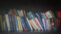 A wooden shelf with books arranged in order.