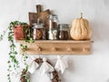 Wooden shelf with cans of cocoa, cookies, marshmallows,pumpkin, wreath, flower and homemade garland Halloween paper ghosts from