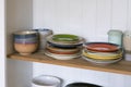 Wooden shelf with kitchen utensils, rustic style. Tableware, plates and bowls stand on a shelf in the kitchen. Cupboard with set Royalty Free Stock Photo