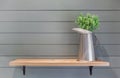 Wooden shelf on plank wall with vase of plastic flower