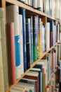 Wooden shelves of books in a library or book shop or bookstore