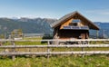 Wooden shepherd lodge with Alpine mountain landscape in Austria.