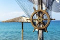 Wooden ship steering wheel and fishing net on the blue sea and sky background