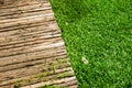 Wooden sidewalk and green lawn for background or texture. Royalty Free Stock Photo