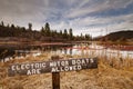 Wooden sign at Baum Lake  advising people that electric powered vessels are permitted.  Shot in mid winter with moody clouds Royalty Free Stock Photo