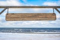 Wooden sign with copy space against blue sky and sea with waves background. Blank wooden sign Royalty Free Stock Photo