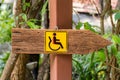 Wooden sign for the handicapped. Royalty Free Stock Photo