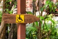Wooden sign for the handicapped. Royalty Free Stock Photo