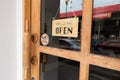 Wooden sign hangs welcome open coffee shop