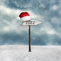 Wooden sign. 2022. Hat of Santa Claus. Snow. The concept of the right direction, in 2022. Copy space. Holidays. Business Royalty Free Stock Photo