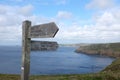 Wooden sign pointing the way along the dramatic clifftops of the coast path, Pembrokeshire, Wales Royalty Free Stock Photo