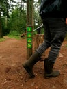 Wooden sign post mile marker on a hiking jogging trail in a forest Royalty Free Stock Photo