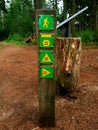 Wooden sign post mile marker on a hiking jogging trail in a forest Royalty Free Stock Photo