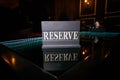 Wooden sign reserve stands on a black glass table Royalty Free Stock Photo