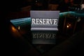 Wooden sign reserve stands on a black glass table Royalty Free Stock Photo