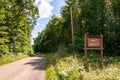 A wooden sign saying HUNT SAFELY on the side of a dirt road in Warren county, Pennsylvania, USA