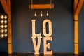 Wooden sign with the word love and light bulbs on black background. Loft idea of background in studio Royalty Free Stock Photo