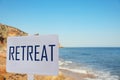 Wooden sign with word Retreat and picturesque view of beautiful beach Royalty Free Stock Photo