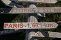 Wooden signpost on ground showing which way is Paris and New Yourk