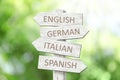 Wooden signpost with names of different languages outdoors Royalty Free Stock Photo