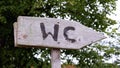 Wooden signpost showing the way to the toilet