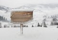 Wooden signpost with snow and mountains