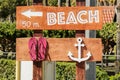 Wooden signpost to the beach with anchor and beach slippers decor Royalty Free Stock Photo