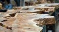 Wooden slabs arranged in a workshop. The surface shows natural patterns and textures. Tools and machinery are visible in the Royalty Free Stock Photo