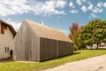 Wooden slat facade of building in green garden with tree and blue sky Royalty Free Stock Photo