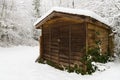 Wooden slat garden shed with snow on the ground and the roof Royalty Free Stock Photo