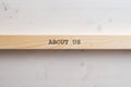 Wooden slat with an About us sign on it