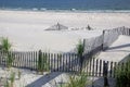 A wooden slated sand fence is partly buried in an ocean beach dune. Royalty Free Stock Photo