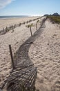 A wooden slated sand fence is partly buried in an ocean beach dune. Royalty Free Stock Photo