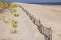 A wooden slated sand fence is partly buried in an ocean beach dune. Royalty Free Stock Photo