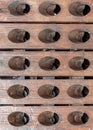 Wooden slats are arranged in a row. There are several holes cut in each board