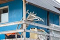 Wooden sledge resting on wooden veranda of blue house in Maniitsoq, Greenland