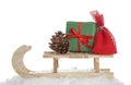 Wooden sleigh with Christmas gifts, pine cone and artificial snow on white background Royalty Free Stock Photo