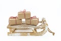 A wooden sleigh with three gifts