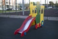Wooden slide bright red blue green in the form of a train in the yard of a residential complex. Playgrounds,