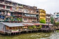 Wooden slums on stilts on the riverside of Chao Praya River in Bangkok Royalty Free Stock Photo