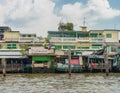 Wooden slums on stilts on the riverside of Chao Praya River Royalty Free Stock Photo