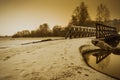 Wooden small bridge on a frozen lake on a frosty winter evening Royalty Free Stock Photo