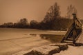 Wooden small bridge on a frozen lake on a frosty winter evening Royalty Free Stock Photo