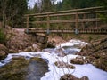 Wooden small bridge over frozen river