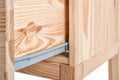Wooden small cabinet with open drawer on white background, closeup.