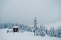 Wooden small church chapel at pine trees covered by snow on mountain Chomiak. Beautiful winter landscapes of Carpathian mountains Royalty Free Stock Photo