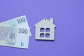 wooden small decorative house and paper money on purple background, sale Royalty Free Stock Photo
