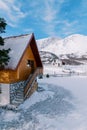 Wooden snow-covered two-story cottage in a small village in a mountain valley Royalty Free Stock Photo