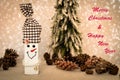 Wooden snowman and pine cones with Merry Christmas and Happy New Year text Royalty Free Stock Photo